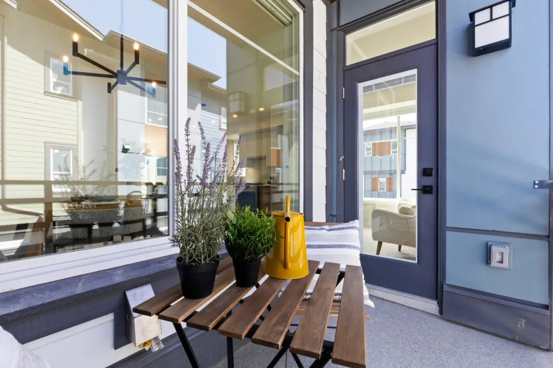 Crofton patio with exterior wall sconce, weatherproof outlet, and interior chandelier visible through glass