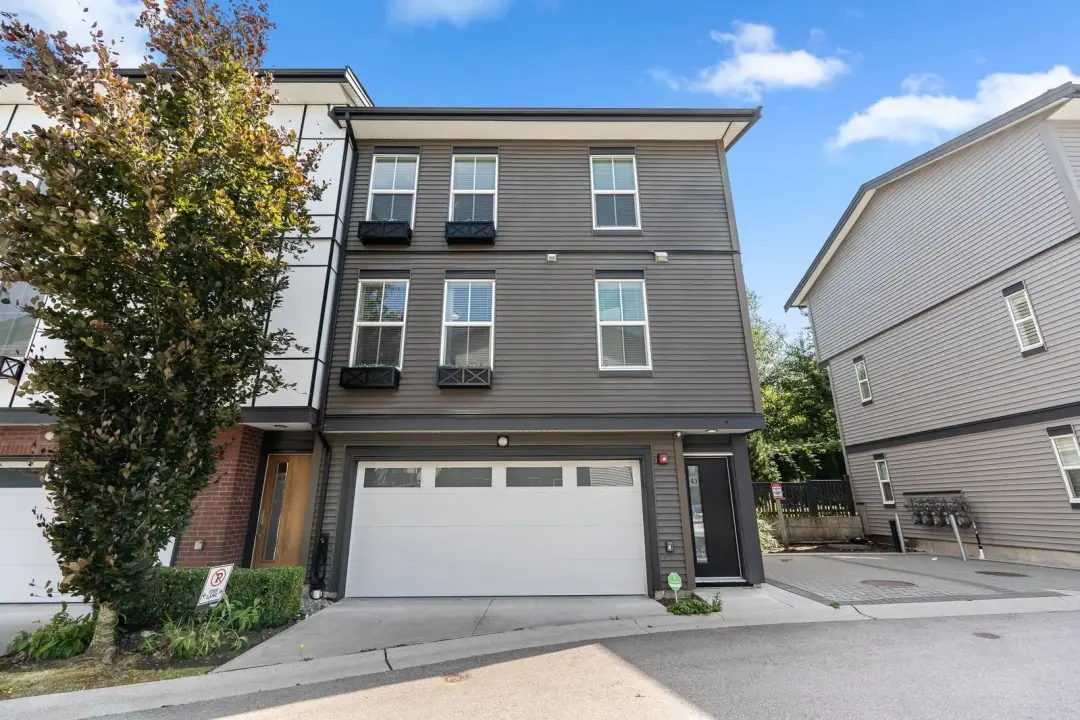 Frame townhomes unit 43 street exterior with white garage and planter boxes