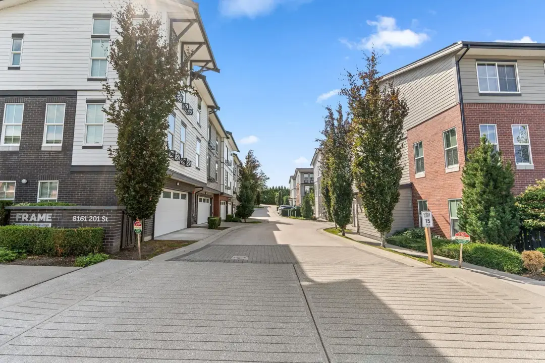 FRAME monument sign at the Langley entrance with internal drive and townhome rows