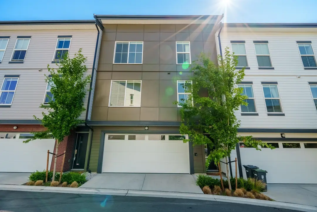 Street facade of Parallel townhomes in Langley with garages and upper balconies