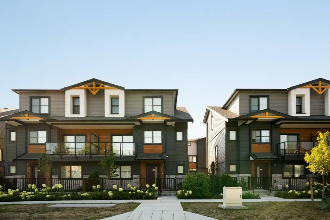 Elwynn Green Surrey townhome exteriors with wood accents, glass balconies, and front landscaping