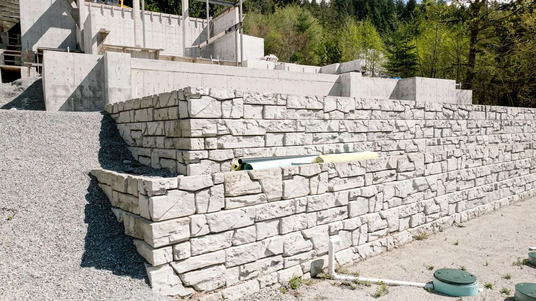 Chauhan Anmore — stone retaining wall with exposed site utilities
