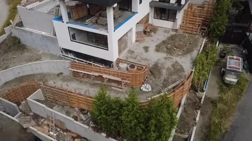 Millstream West Vancouver construction site with retaining walls and modern white home under build